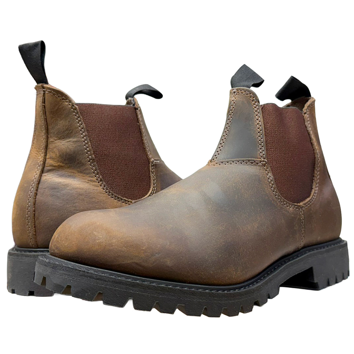 A pair of distressed brown leather Chelsea boots with dark brown elastic side panels and black pull tabs, shown on a solid white background.
