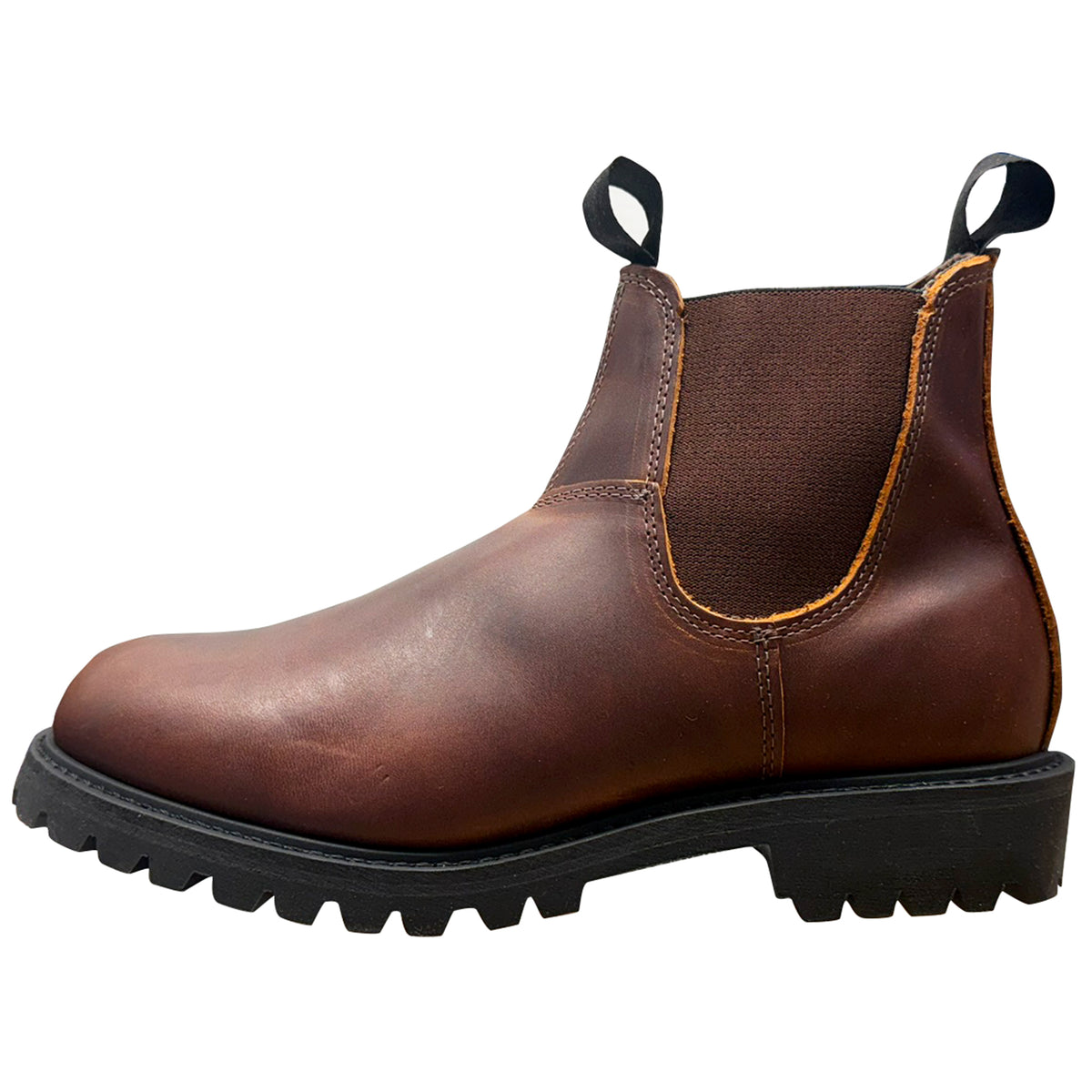A brown leather Chelsea boot with a black elastic side gore, black pull tabs, and a rugged black lug sole, shown from a side profile on a white background.