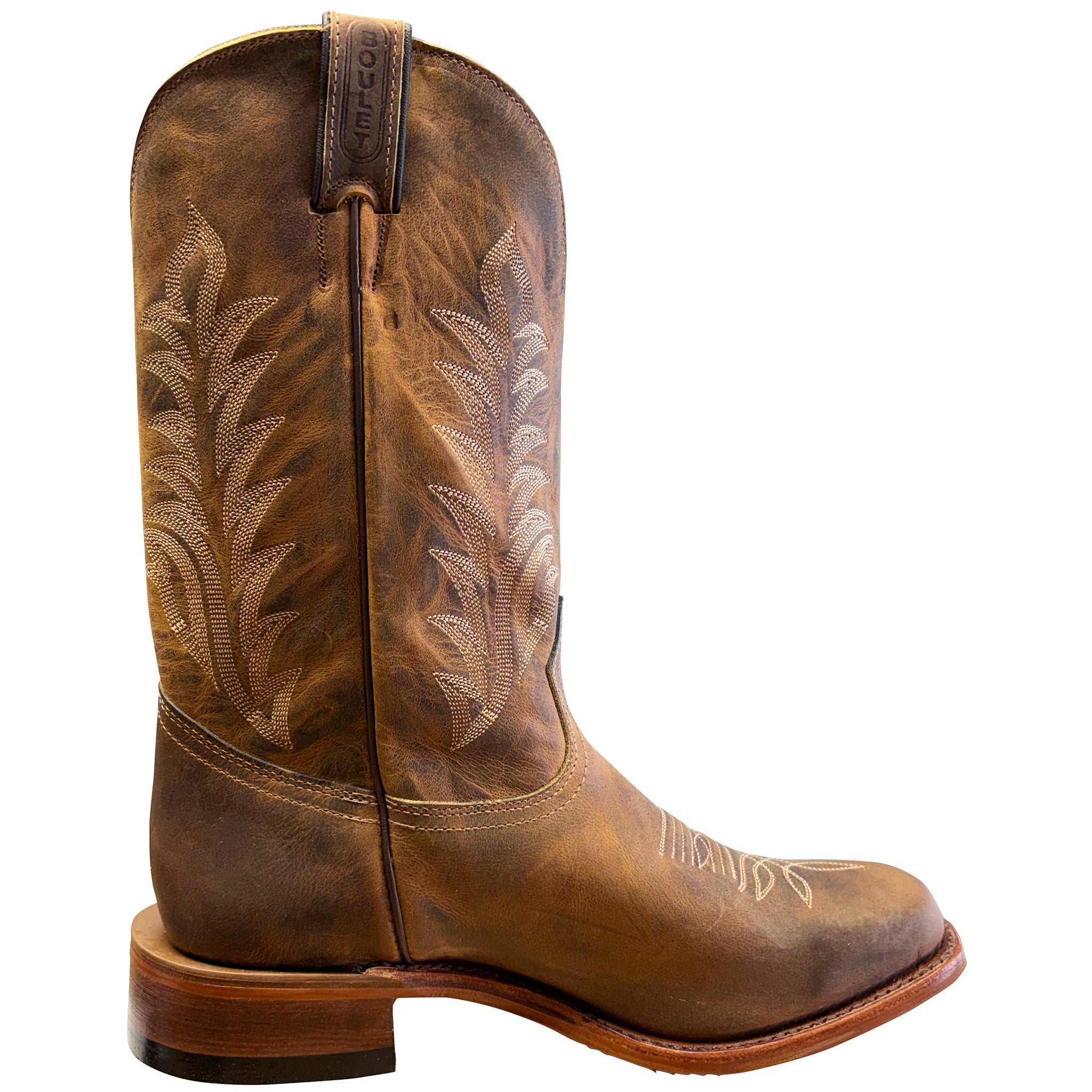 Brown cowboy boot with intricate embossing on a white background