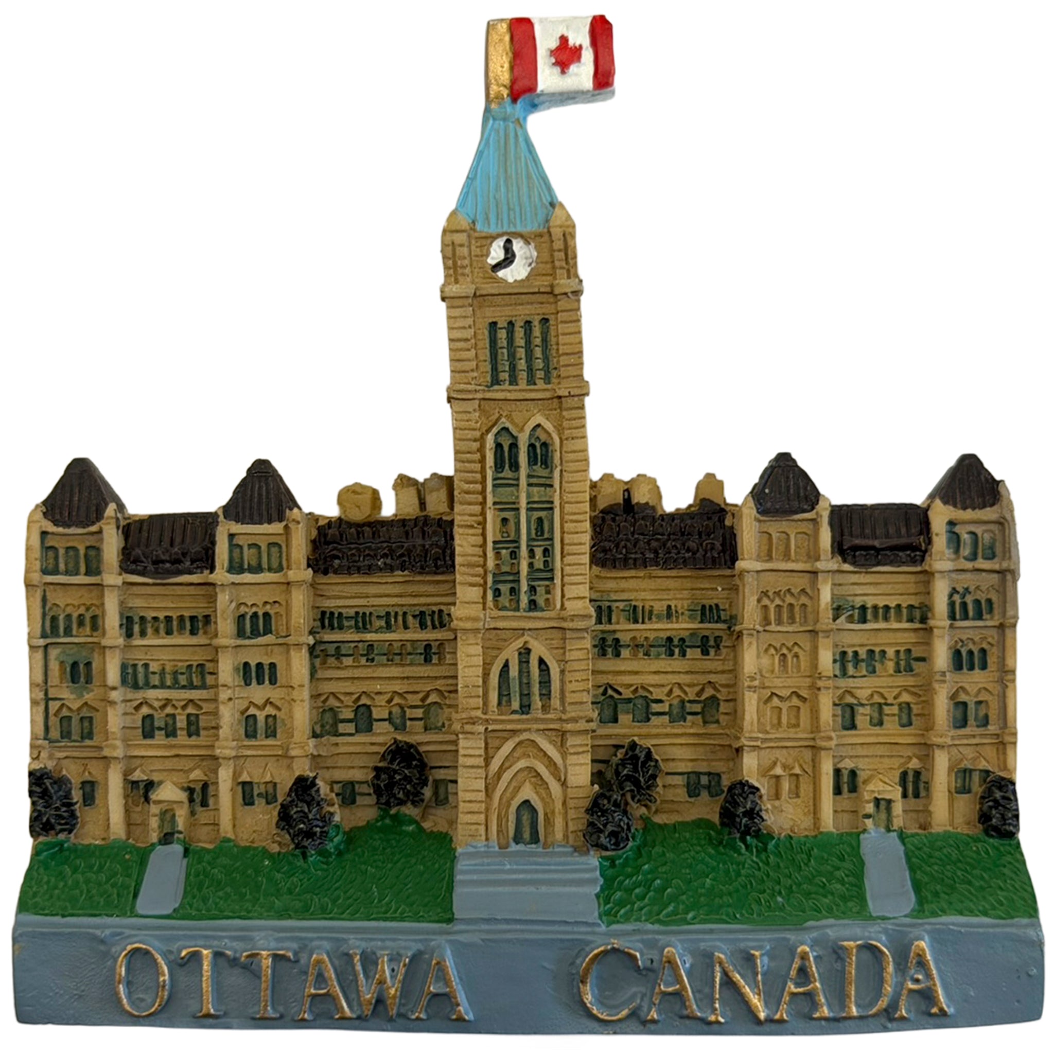 A miniature decorative model of the Ottawa Parliament Building with a Canadian flag on top, green lawn details, and 'OTTAWA CANADA' written in gold letters on a gray base, isolated on a white background.